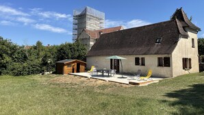A house with a tiled roof, a small porch, and a table with chairs. - Country house near Cabreret (Orniac)