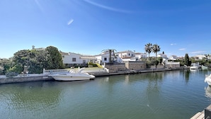 Un port de plaisance avec des bateaux, des bâtiments blancs et un ciel bleu azur.