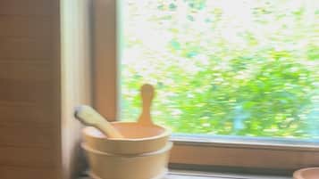 A kitchen window with a view of greenery outside.