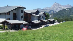 A row of traditional chalet-style buildings with a mountain backdrop.