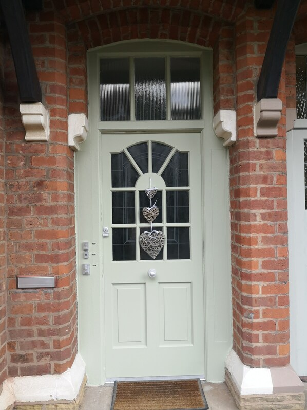 A white door with a glass panel and a heart-shaped decoration.