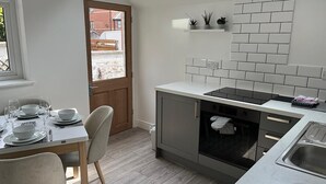 Una cucina moderna con zona pranzo, dotata di forno integrato, lavello e finestra con vista sulla strada.