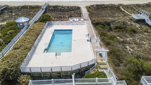 An aerial view of a beachside hotel with a swimming pool, wooden walkways, and a beach in the background. - Ocean Isle Beach Getaway Is A Slice Of Heaven (Ocean Isle Beach)