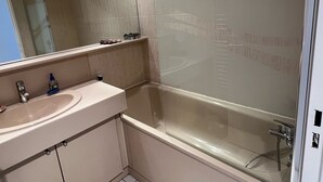 Un baño moderno con una bañera, un lavamanos y un espejo.