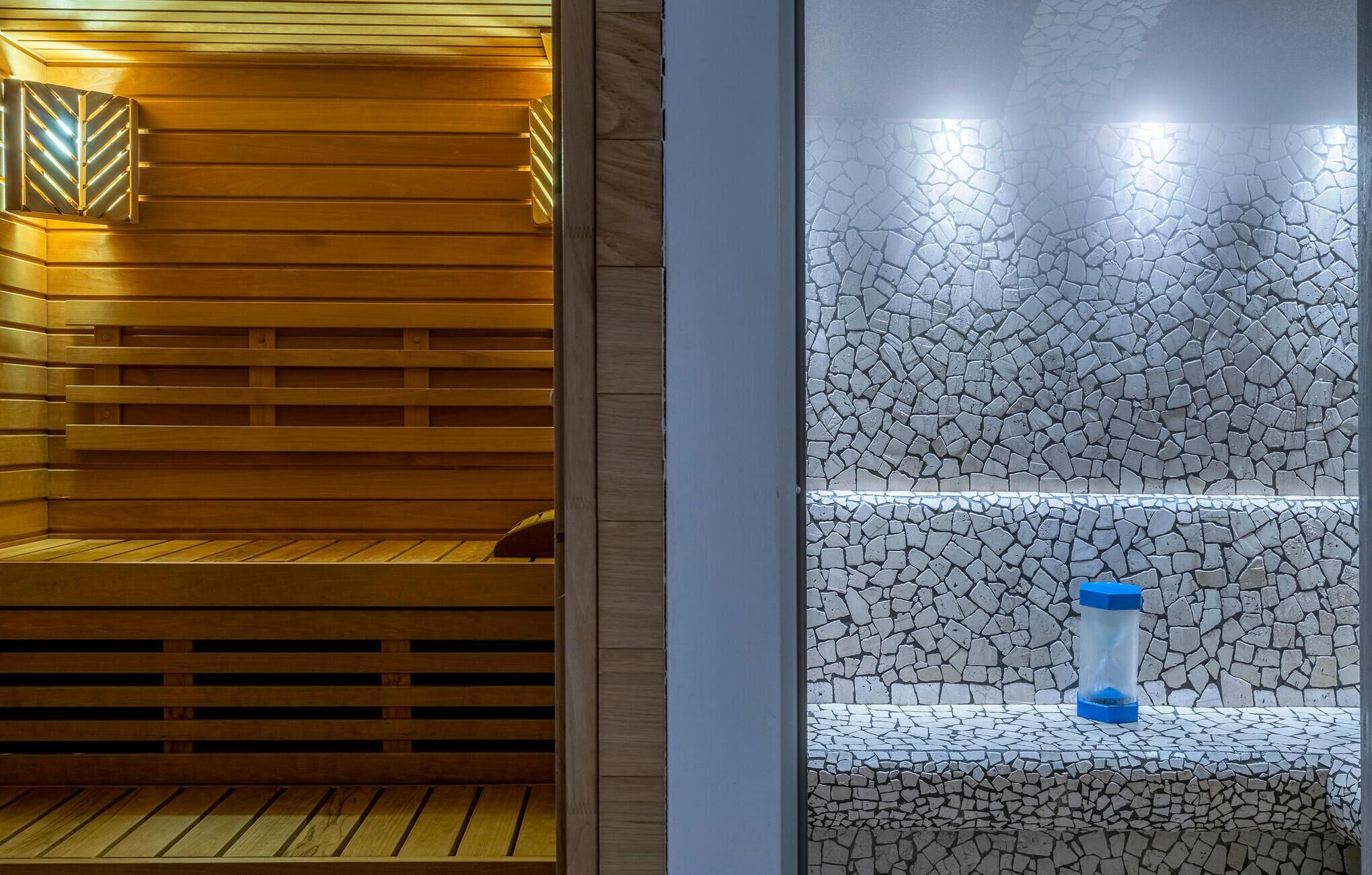 Sauna, jossa on puiset lauteet ja kiviseinä.