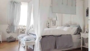 A bedroom with a canopy bed, a bedside table, a nightstand, and a window with curtains. - Magnificent residence with heated indoor pool (Guipry-Messac)