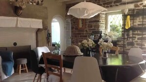 A dining area with a round table, chairs, and a hanging light fixture. - Magnificent residence with heated indoor pool (Guipry-Messac)