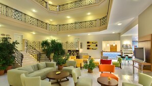A multi-level indoor space with a central staircase, multiple seating areas, and a television. - Novella Apart Hotel (Alanya)