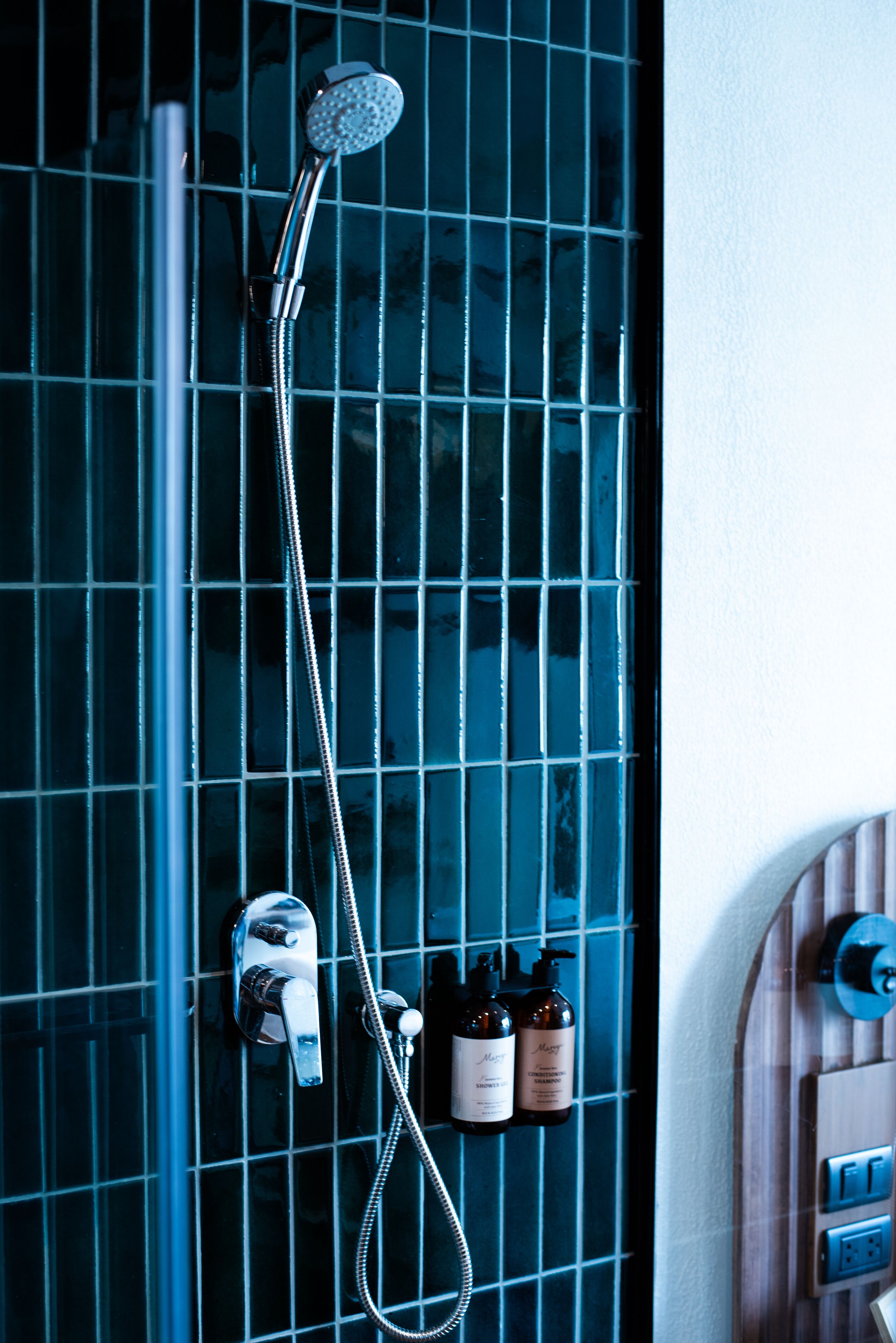 Un bagno con doccia, un portasciugamani e un set di articoli da toilette.