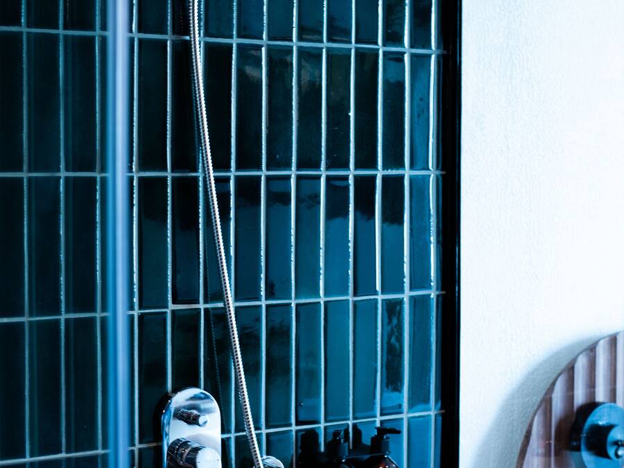 Un bagno con doccia, un portasciugamani e un set di articoli da toilette.