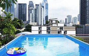 A rooftop swimming pool with a view of a city skyline. - Karaarom Hotel (Bangkok)