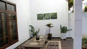 Un comedor con una mesa de madera, plantas en macetas y obras de arte en la pared.