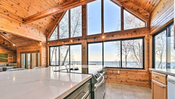 A modern kitchen with large windows, a central island, and a view of the outdoors. - Lakefront Applegate Retreat w/ Private Beach! (Applegate)