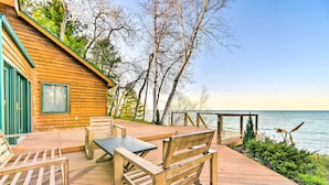 A wooden deck with outdoor furniture, a view of the water, and a wooden cabin structure. - Lakefront Applegate Retreat w/ Private Beach! (Applegate)