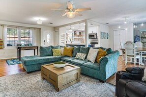 A living room with a sectional sofa, a coffee table, and a ceiling fan.