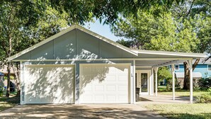 Ein einstöckiges Haus mit Garage und überdachter Veranda.