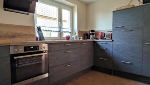 Eine moderne Küche mit Backofen, Mikrowelle und Kaffeemaschine.
