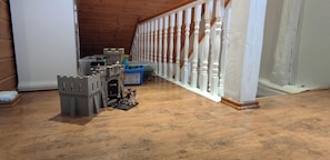 Ein Zimmer mit Holzboden, einem Burgenmodell und einer weißen Geländer.