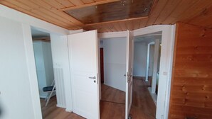 Ein Zimmer mit Holzboden, weißen Wänden und einer schrägen Decke.