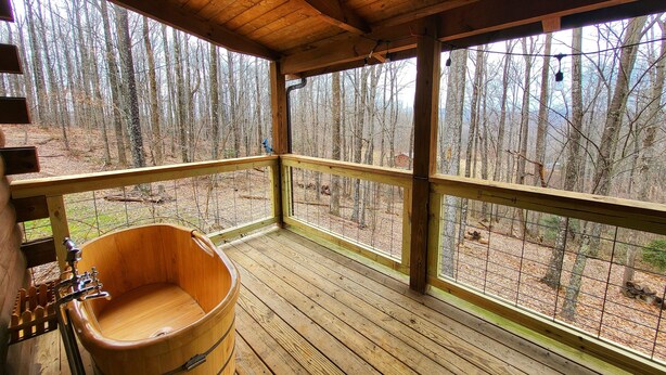 A wooden deck with a wooden tub, wooden railings, and a view of a forest. - New River & Gauley River family cabin -10 minutes to state & national parks (Hico)