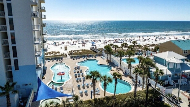 Een resort met meerdere zwembaden, een strand en uitzicht op de oceaan.