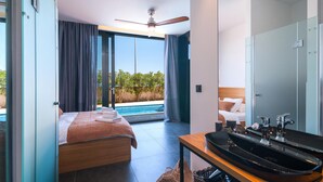 A modern bedroom with a bed, a bathroom with a sink, and a view of a pool. - Awesome home in Sutivan (Sutivan)