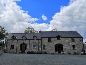 Traditional stone building with a central entrance and pitched roof.