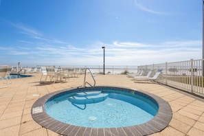 Une piscine avec des chaises longues et une clôture blanche.