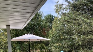 A wooden deck with wicker furniture, including two lounge chairs and a table with chairs. - Luxurious Getaway - Near Sandbanks and Wineries (Picton)