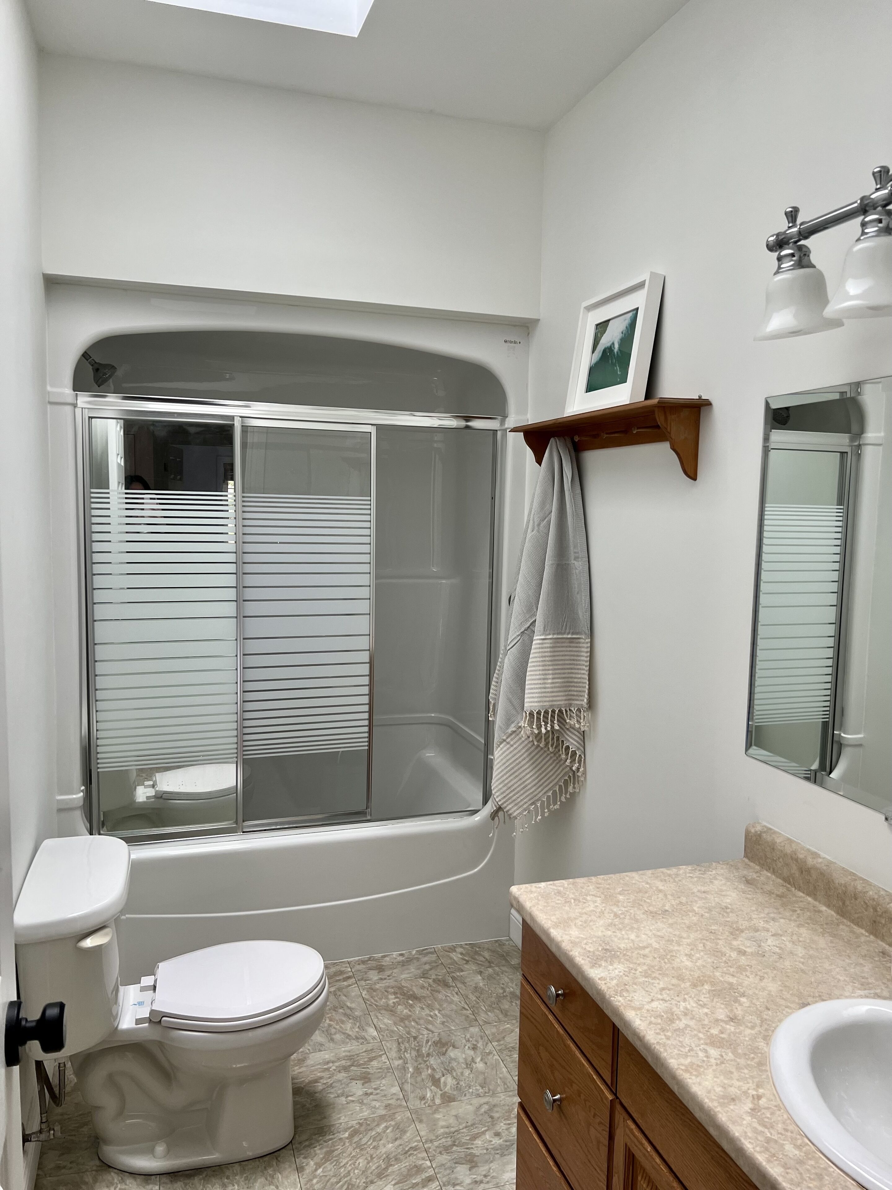 A modern bathroom with a bathtub, toilet, vanity, and a shower enclosure.
