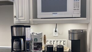 A kitchen with a coffee maker, a bag of coffee beans, and a microwave. - 3 BR, 2 Bath home in Emerald Isle! Golf cart, beach chairs & Shibumi included! (Emerald Isle)