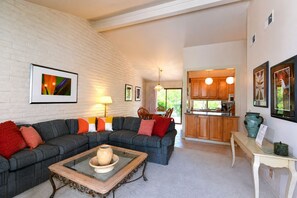 A living room with a sectional sofa, a coffee table, and a dining area with chairs. - Perfect Wine Country Retreat at Silverado (Napa)