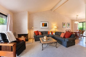 A living room with a fireplace, a sectional sofa, a coffee table, and a dining area with chairs. - Perfect Wine Country Retreat at Silverado (Napa)