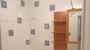 A bathroom with a bathtub, a wooden vanity with a mirror, and decorative tiles on the walls. - Charming village house in Provence, French Riviera South of France, 6km from sea (La Valette-du-Var)