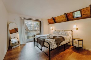 A bedroom with a bed, a small table, a window, and a wooden ceiling. - Spacious North Cascades Riverside A-Frame w/ Mt Baker Views - Dog-Friendly (Concrete)