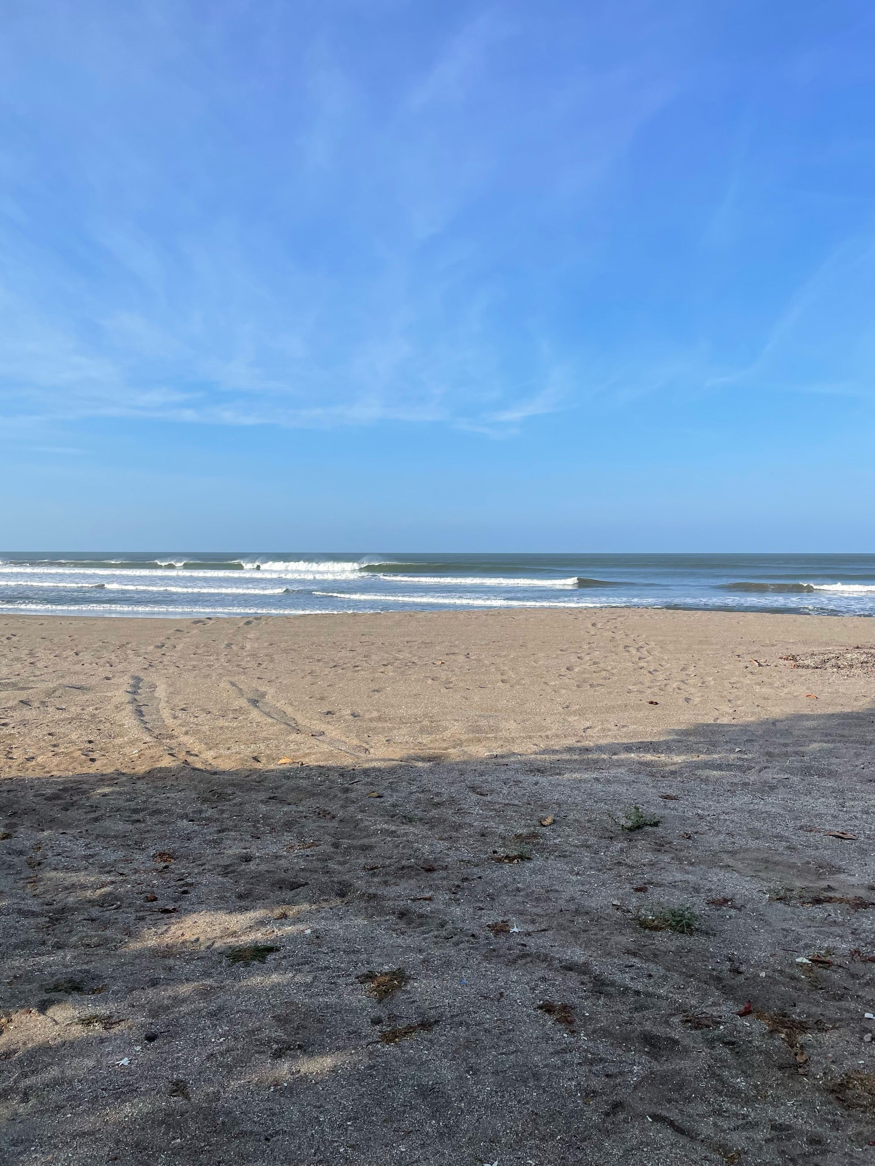 A beach with a clear sky and ocean waves.
