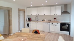 A modern kitchen with white cabinets, a built-in oven, and a dishwasher.