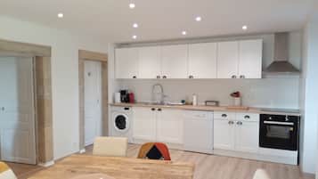 A modern kitchen with white cabinets, a built-in oven, and a dishwasher.