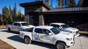 Three white pickup trucks parked in front of a building with a stone facade and metal roof. - Park Place Peak 10 Condo: Walk To Lift, Main Street (Breckenridge)