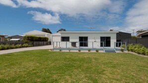 A modern two-story house with a flat roof, large windows, and a small front porch. - Cosy Coastal Retreat in Stieglitz with Water Views (Stieglitz)