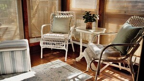A sunlit room with wicker chairs, a small table, and a potted plant. - 13 Collins Street, Unit B, Dewey Beach, Delaware (Dewey Beach)