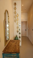 Un corridoio con un tavolo in legno, uno specchio e specchi decorativi a parete.