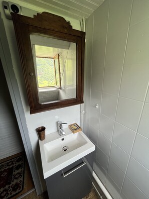 A bathroom with a white sink, a wooden-framed mirror, and a window. - La Maison de Berger des Hautes Pyrénées - A Pyrenean Homestead (Gazost)