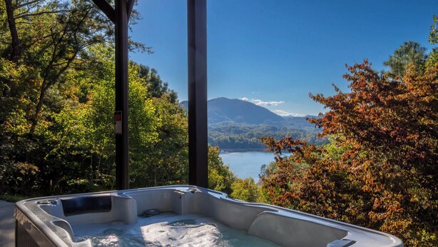 A hot tub with a clear view of a lake and mountains in the background. - Luxury Lakeview Cabin with Hot Tub and Game Room! (Bryson City)
