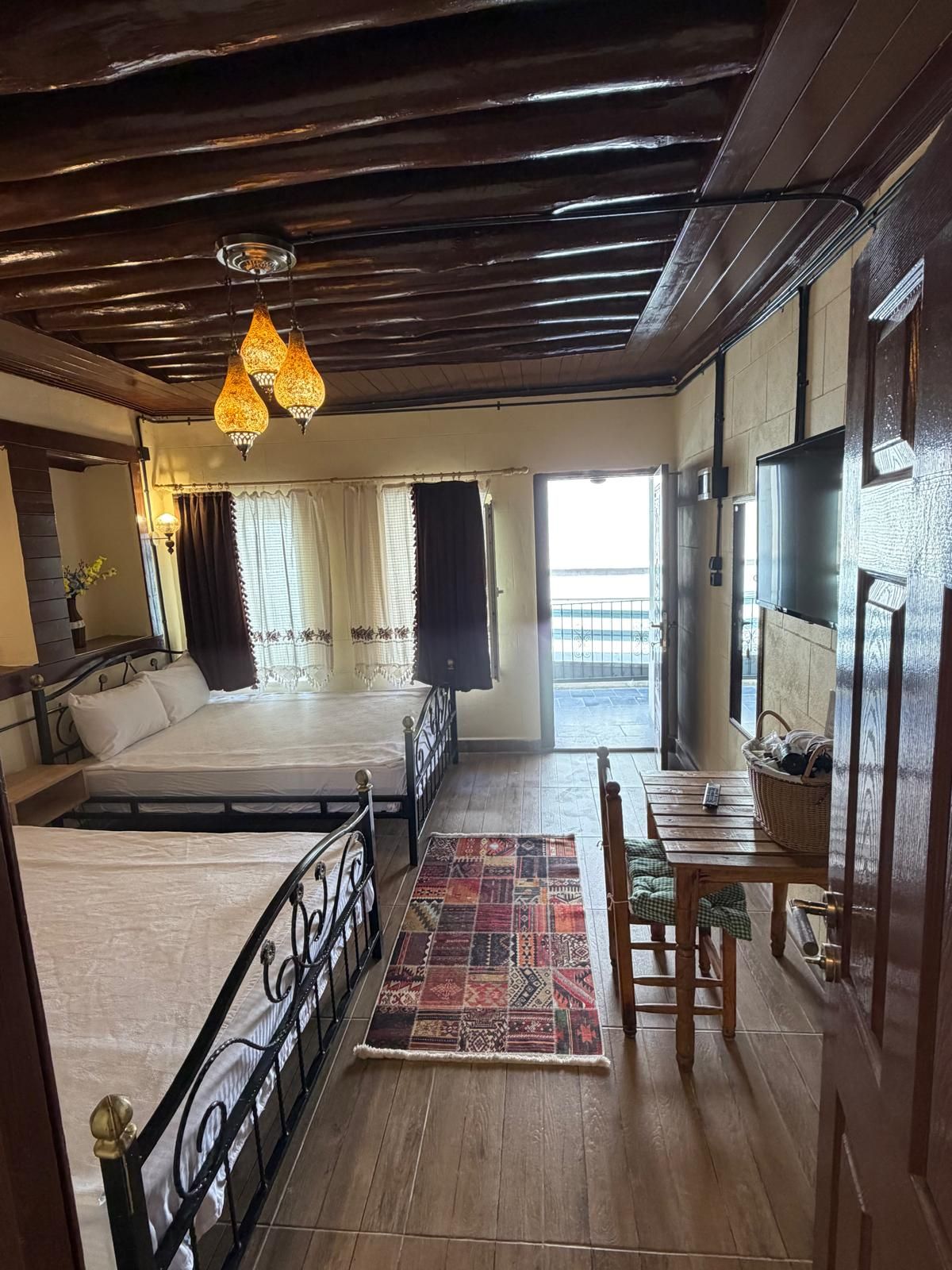 Ein Zimmer mit zwei Betten, einem Essbereich und Blick durch ein großes Fenster.