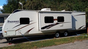 A Passport ULTRA LITE RV with a sliding door, two windows, and a small air conditioning unit on the roof. - Frontier days special, RV camper sleeps 6 (Cheyenne)