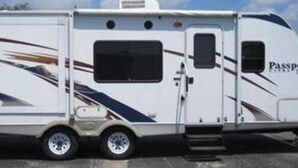 A white RV with a streamlined design, a small window, and the word "Passport" on the side. - Frontier days special, RV camper sleeps 6 (Cheyenne)