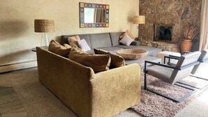 A living room with a sofa, armchair, and a fireplace. - Great Condo just 3 min walk to Lionshead Gondola. (Vail)