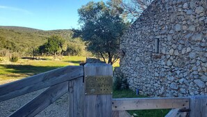 A wooden gate with a sign reading 'Bergerie des Rèves' and a stone wall. - eco-lodge with natural swimming pool (PUECHABON)