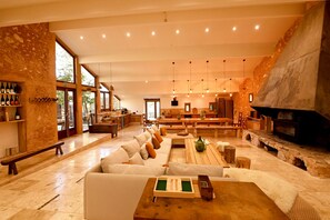 A spacious living area with a stone wall, a fireplace, and a wooden bench.